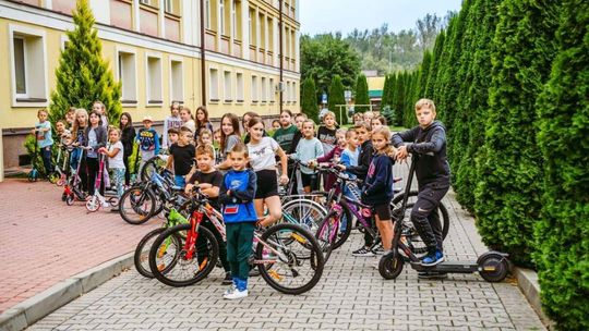 Uczniowie na rowerach przed szkołą