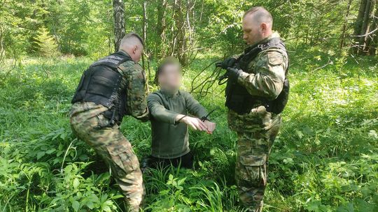 zdjęcie przedstawia mężczyzn w mundurach w lesie