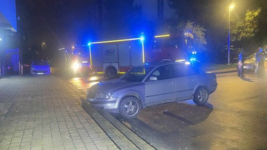 zdjęcie przedstawia samochód stojący na parkingu, za nimi wóz straży pożarnej