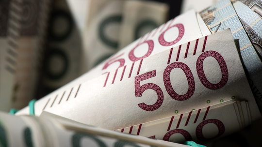 zdjęcie przedstawia plik banknotów obwiniętych gumką