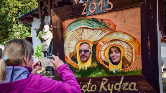 zdjęcie przedstawia osoby, które stoją za planszą w wyciętymi otworami na głowę