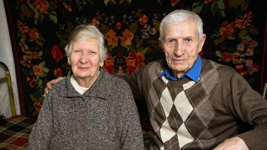 starsza kobieta i mężczyzna pozujący do zdjęcia, w tle pokój