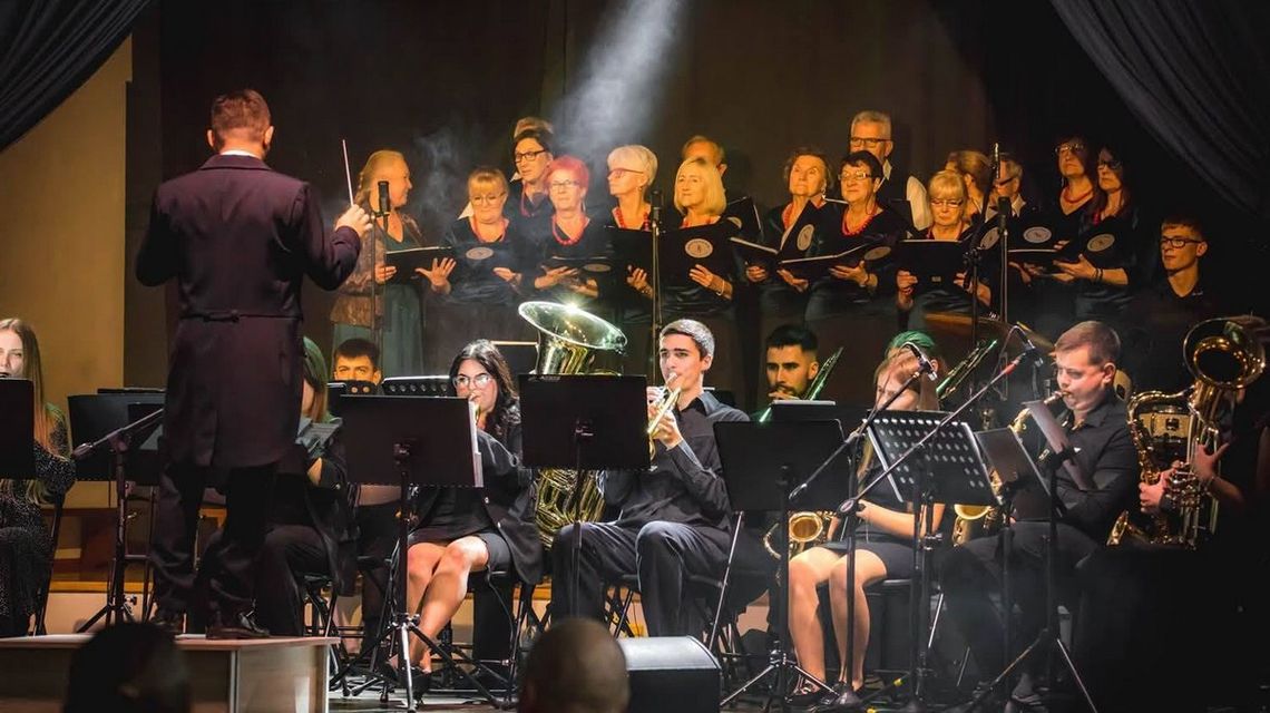 20 lat muzycznej historii w Brunarach. Jubileusz orkiestry, która od pokoleń łączy mieszkańców grupa osób grająca na instrumentach, przed nimi stoi dyrybent