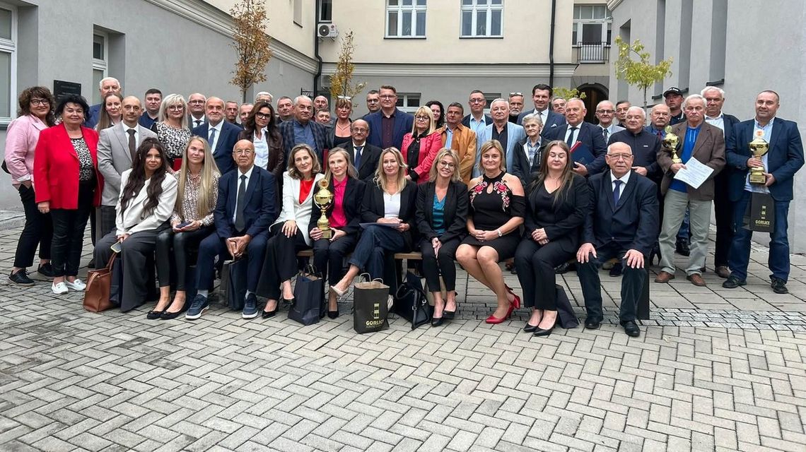 duża grupa osób stojąca i siedząca na krzesełkach na dziedzińcu ratusza w gorlicach