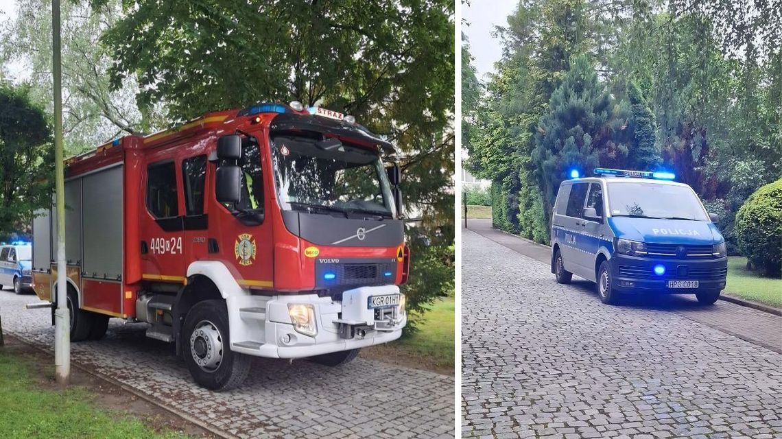 Alarm bombowy w szkole. Na miejscu strażacy, policja i pirotechnik zdjęcie przedstawia samochód straży pożarnej i policji stojący na jezdni