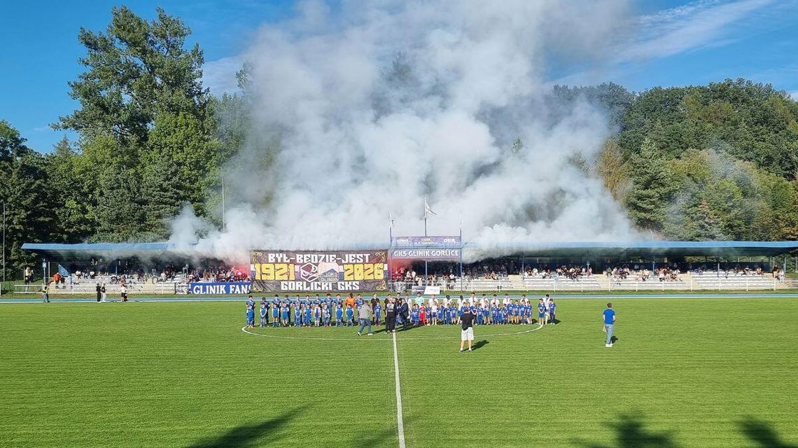 Biało-niebieskie piłkarskie święto w Gorlicach. Tak wygląda mecz przyjaźni z Karpatami Krosno dym nad trybuną stadionu, drużyny na boisku przed meczem