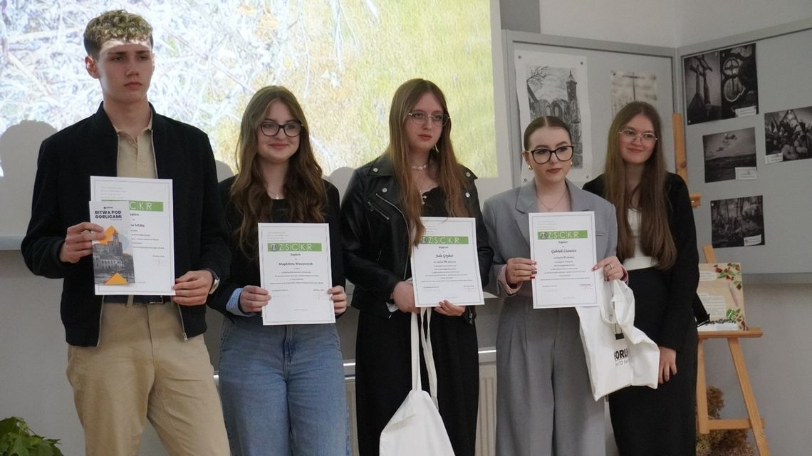 zdjęcie przedstawia uczennice i uczniów trzymających dyplomy