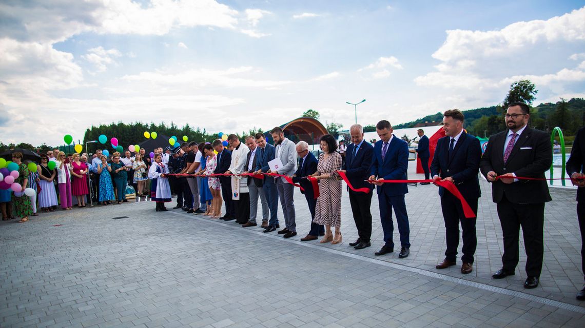 zdjęcie przedstawia grupę osób które przecina wstęgę na basenie