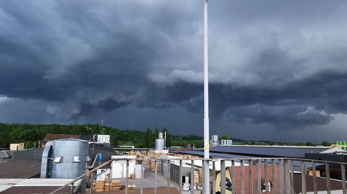 zdjęcie przedstawia ciemne chmury nad zabudowaniami