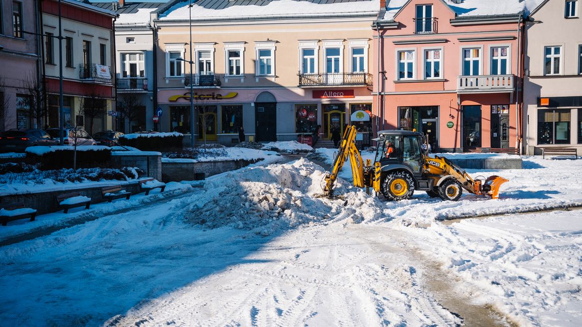 Chodźcie na górkę do centrum miasta. Weźcie ze sobą sanki i dobry humor zdjęcie przedstawia koparkę przesuwającą śnieg