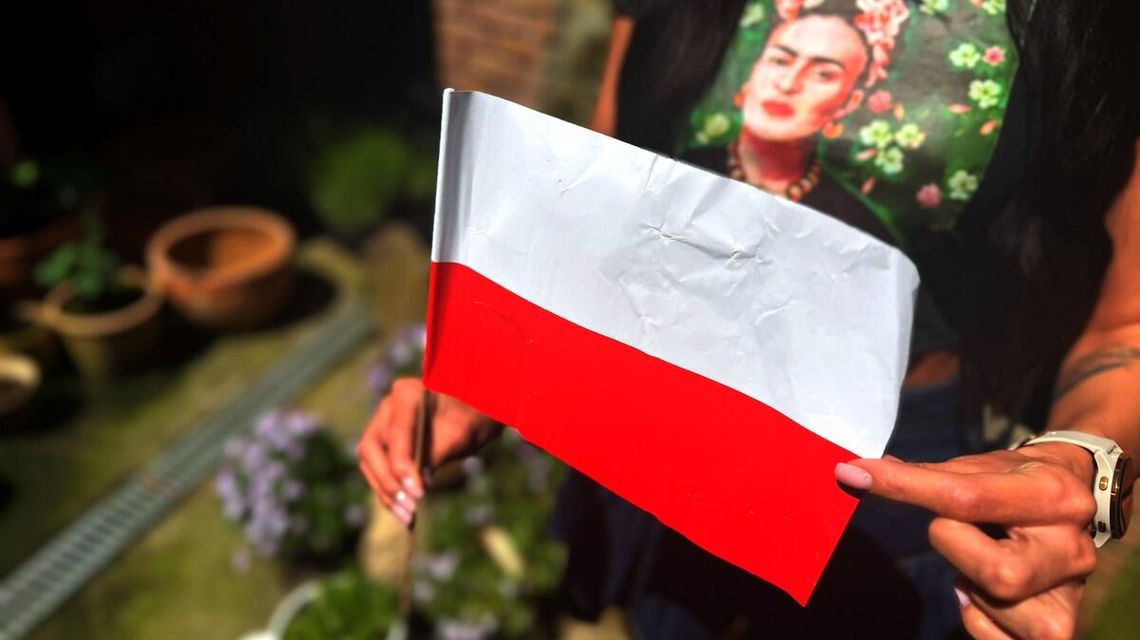 zdjęcie przedstawia dziewczynę, która trzyma flagę przed sobą