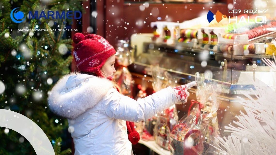 zdjęcie przedstawia dziecko na tle kiermaszu świątecznego