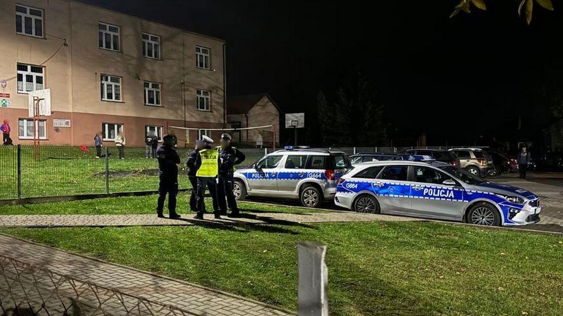 policjanci przed budynkiem szkoły w Łużnej