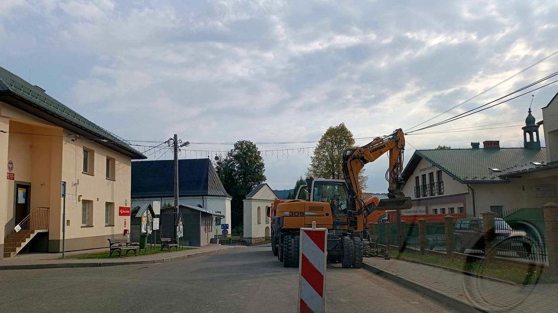 koparka na jezdni, która jest remontowana, widok zza szyby samochodu