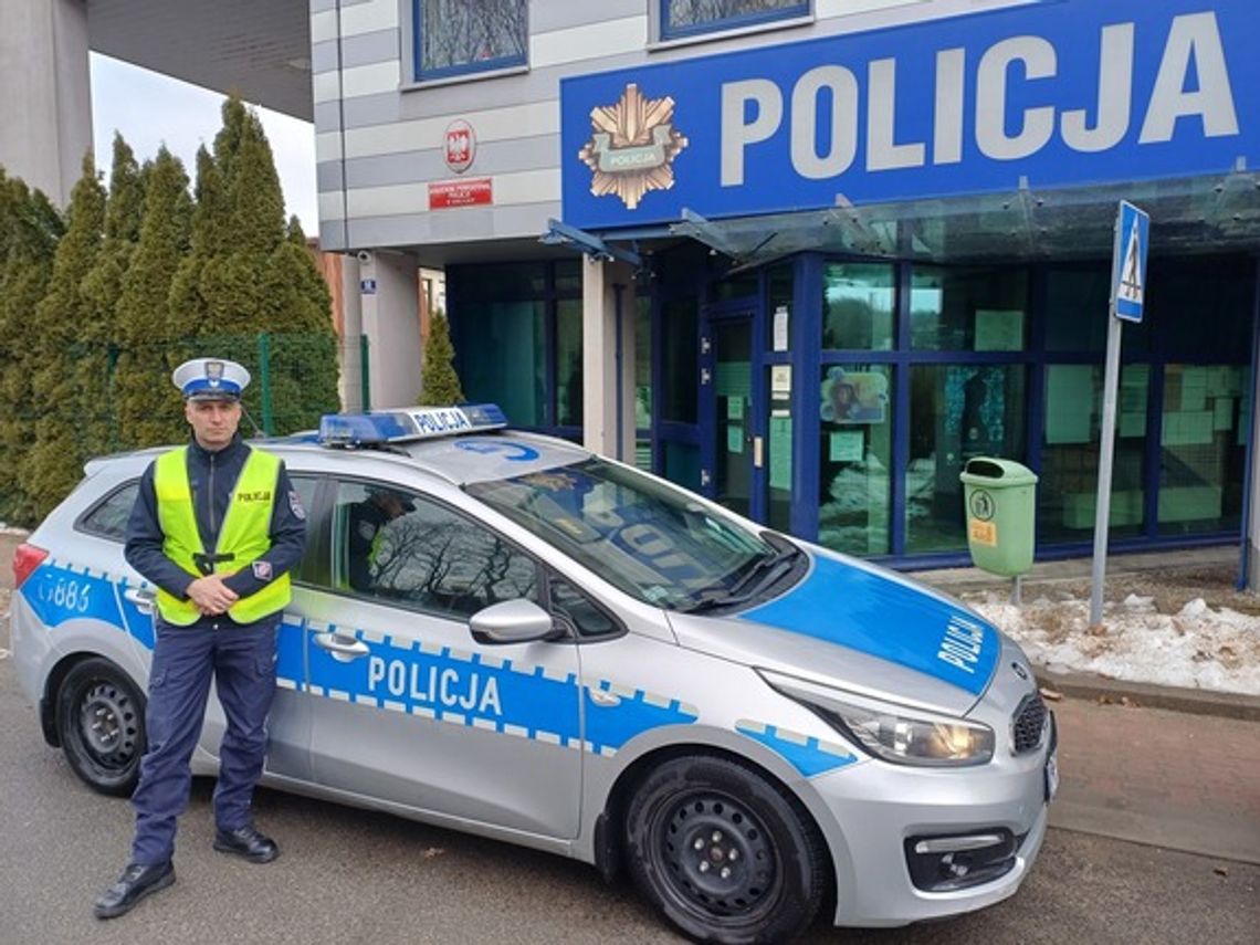 zdjęcie przedstawia policjanta na tle budynku policji