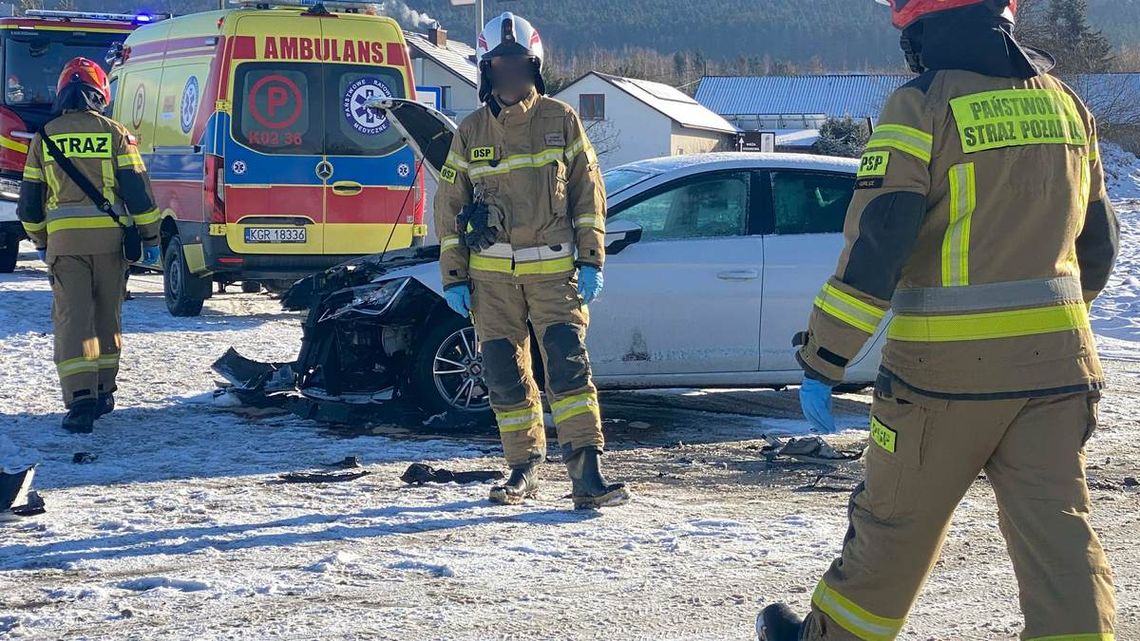 zdjęcie przedstawia samochód strażacki i uszkodzony samochód na jezdni pokrytej śniegiem