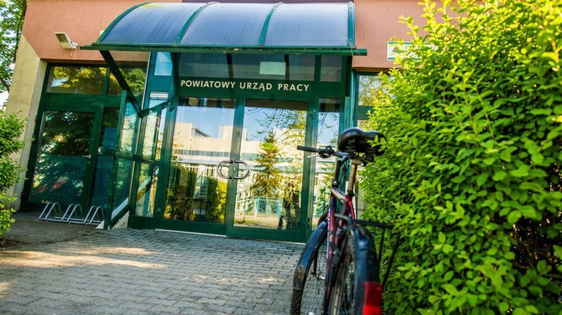 Dużo ofert zatrudnienia. Szukasz pracy od zaraz? Sprawdź, kto potrzebuje pracowników zdjęcie przedstawia wejście do budynku, przed nim stoi rower