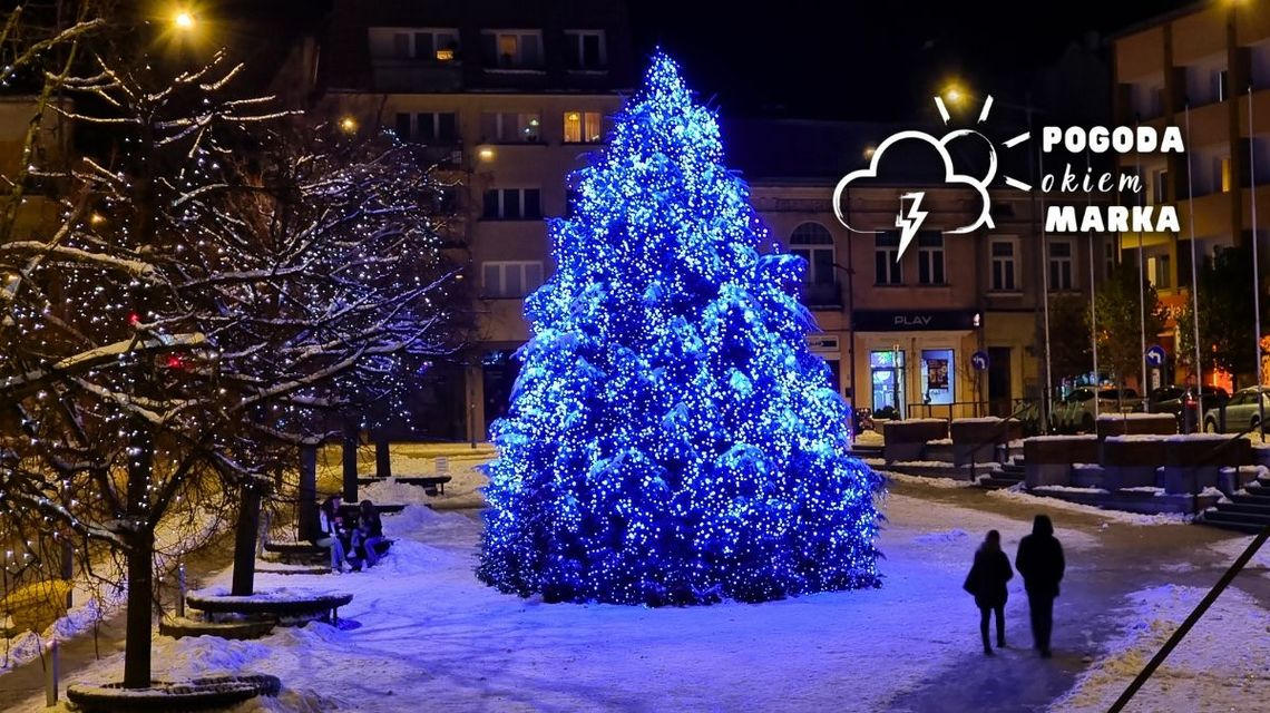 choina na gorlickim rynku w nocy obok niej przechodzi dwójka ludzi