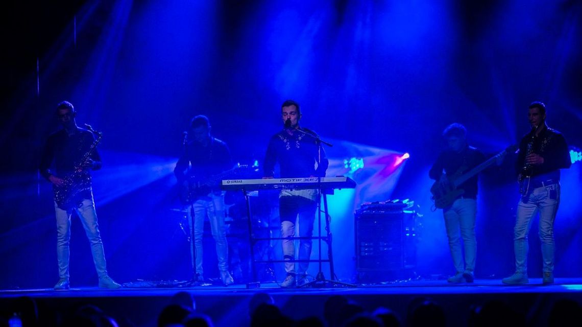 zdjęcie przedstawia kilku mężczyzn z instrumentami na scenie