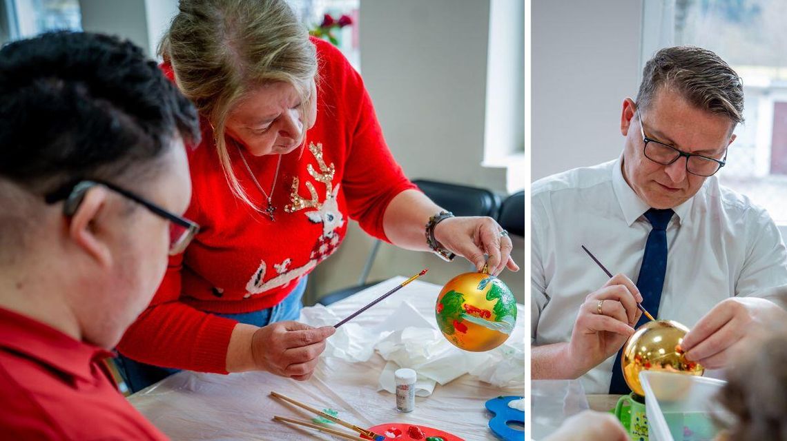 Zdjęcie przedstawia Marcina Krzemińskiego i podopiecznych malujących bombki choinkowe
