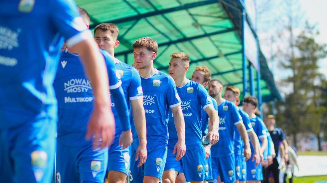 zdjęcie przedstawia drużynę piłki nożnej witającą się z kibicami