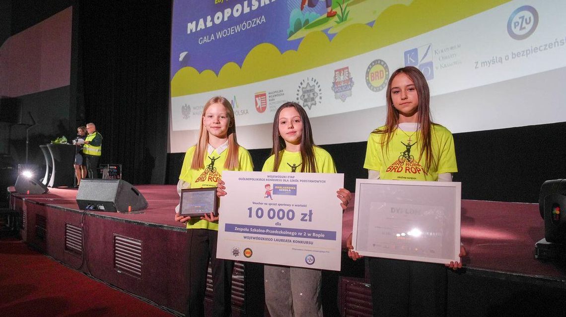 Zdjęcie przedstawia dzieci trzymające bon z nagrodą pieniężną