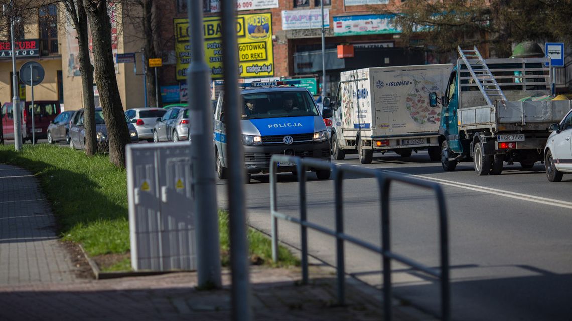zdjęcie przedstawia radiowóz jadący ulicą w mieście