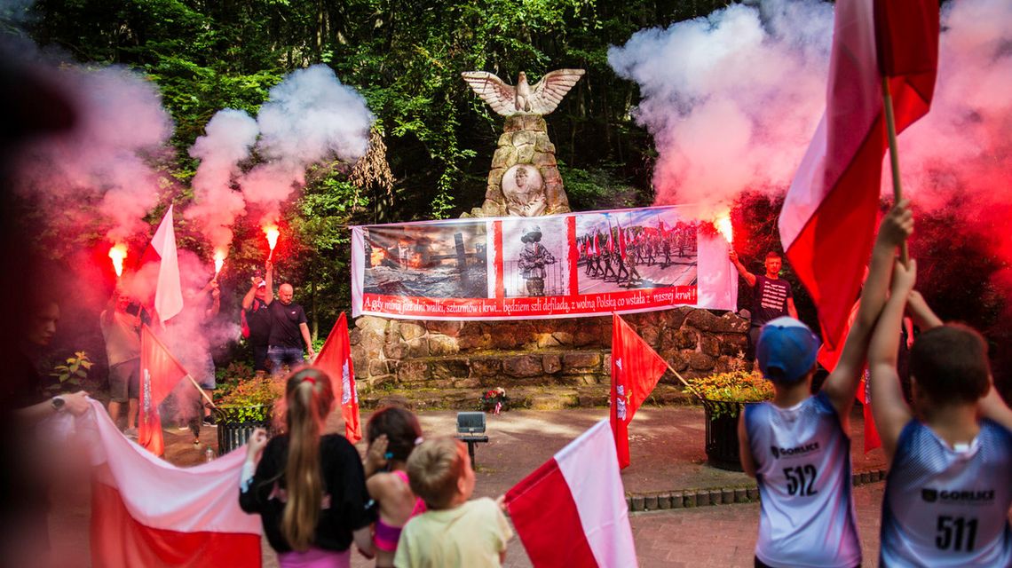 zdjęcie przedstawia mężczyzn z racami