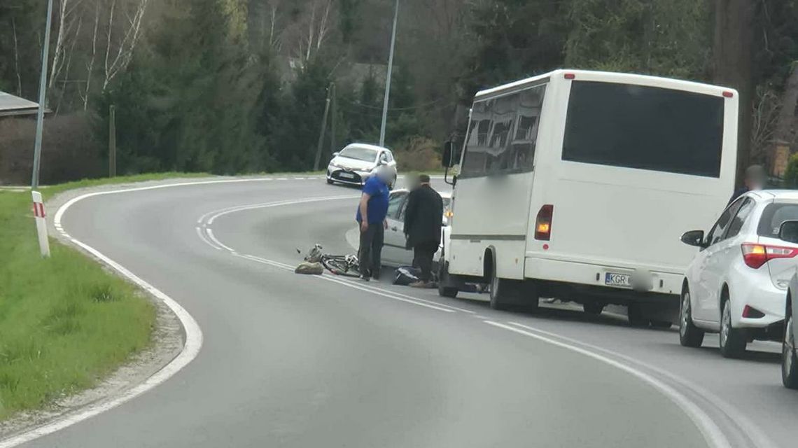 zdjęcie przedstawia samochody na drodze, przed nimi stoją ludzie