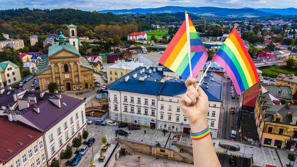 zdjęcie przedstawia widok z góry na zabudowania miasta i flaga LGBT