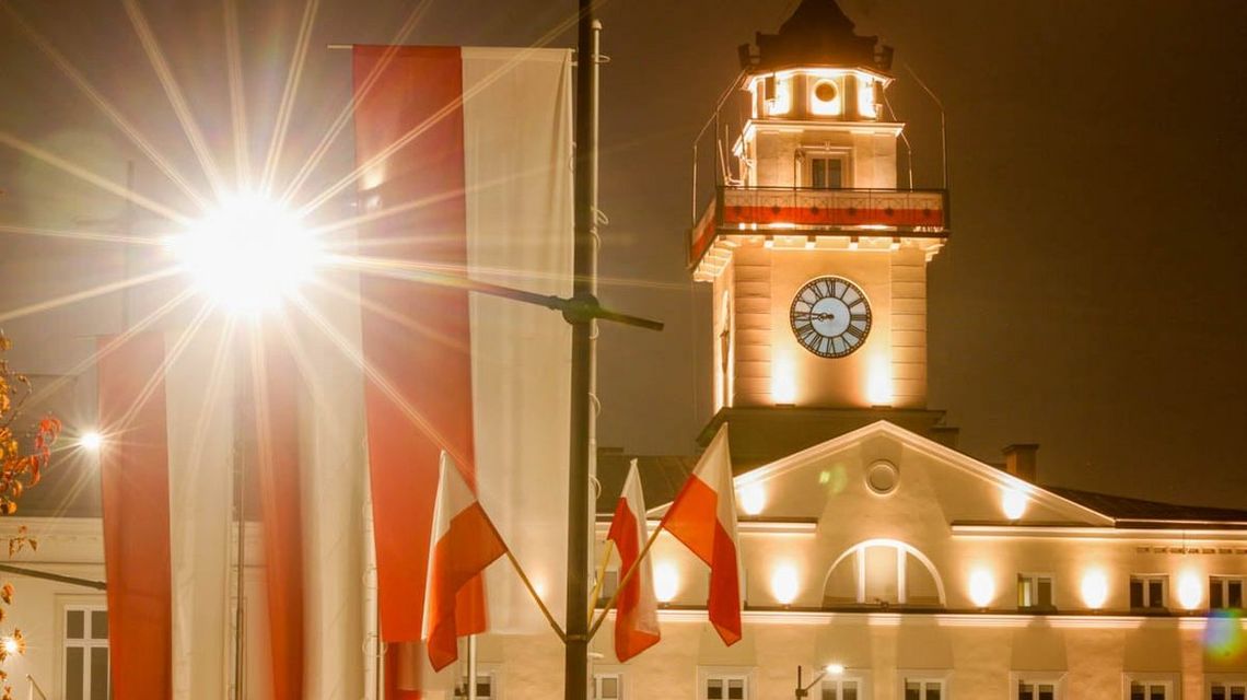 zdjęcie przedstawia ratusz i flagi w nocy