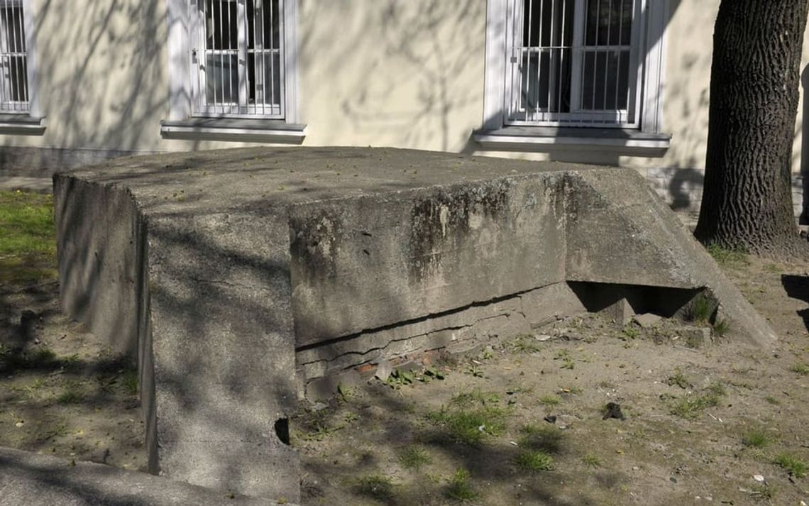 zdjęcie przedstawia betonowy schron przed budynkiem