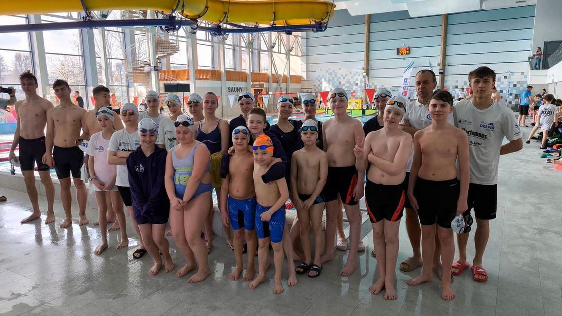 zdjęcie przedstawia grupę dzieci w strojach kąpielowych na basenie