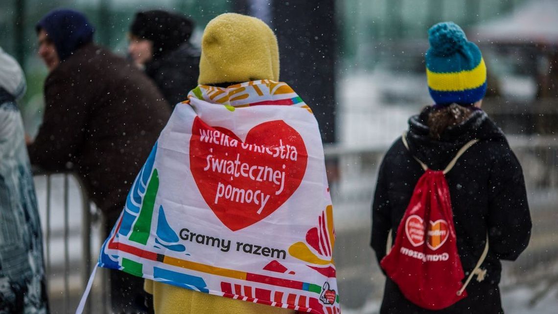 kobieta z dzieckiem widok z tyłu na plecach mają chusty z napisem wośp