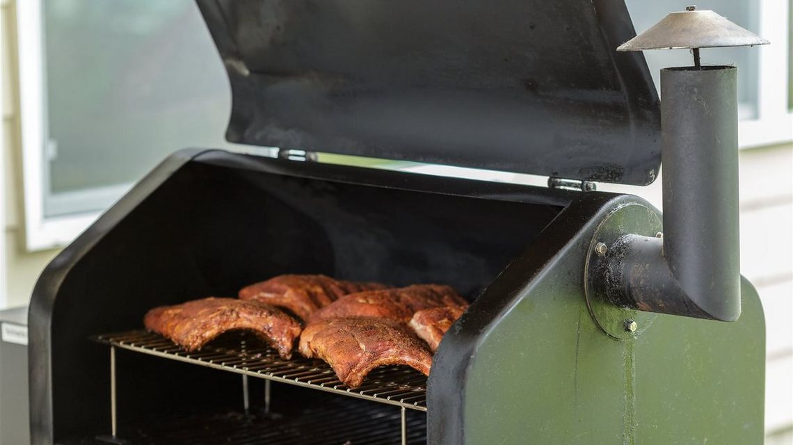 Jak czyścić wędzarnię elektryczną, aby służyła przez lata? zdjęcie przedstawia grill na którym smaży się mięso