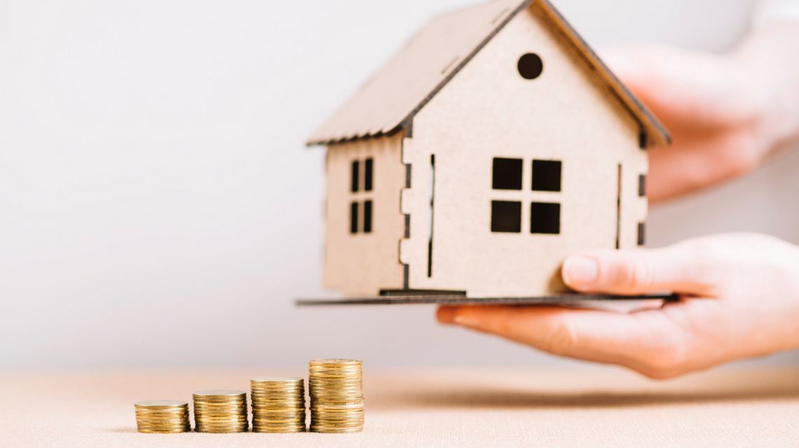 Jak ulga termomodernizacyjna współpracuje z dotacją na okna i jakie odliczenia można uzyskać w PIT? zdjęcie przedstawia makietę domu trzymaną w dłoniach