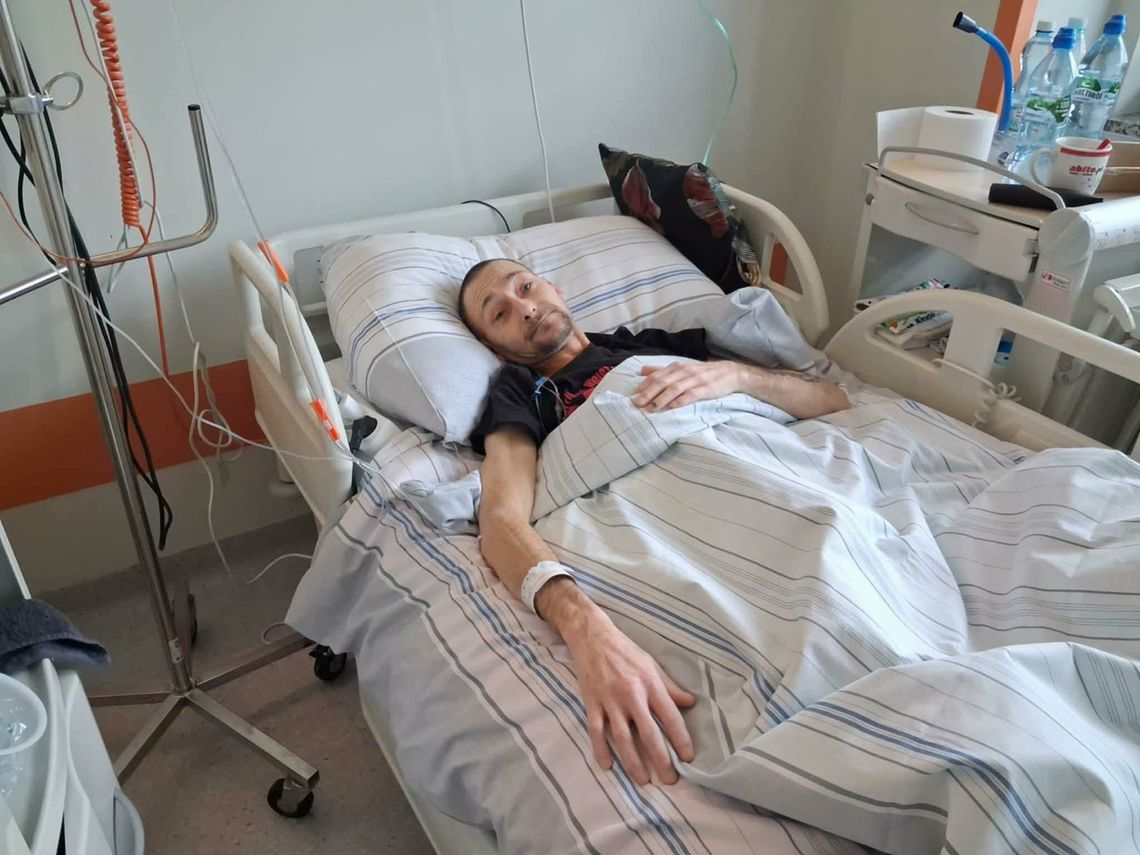 zdjęcie przedstawia osobę leżącą w szpitalnym łóżku