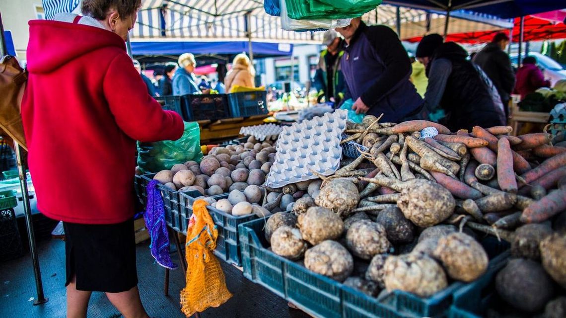 zdjęcie przedstawia plac targowy w mieście i ludzi między straganami