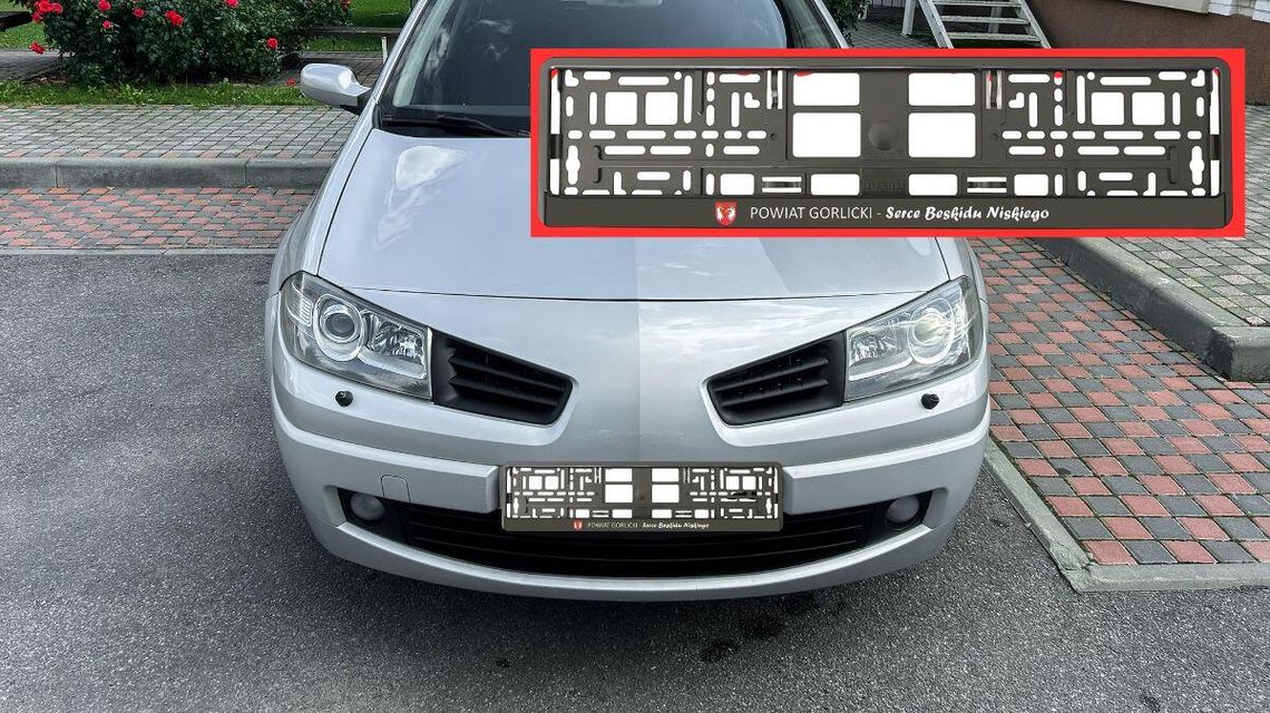 zdjęcie przedstawia samochód na drodze, obok widok ramki do rejestracji w powiecie gorlickim