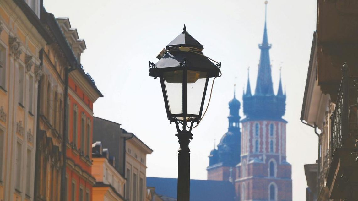 latarnia uliczna, w tle wieża kościoła mariackiego w krakowie