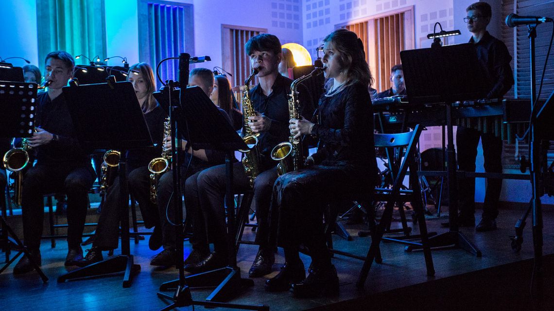 zdjęcie przedstawia młodzież grającą na instrumentach na scenie