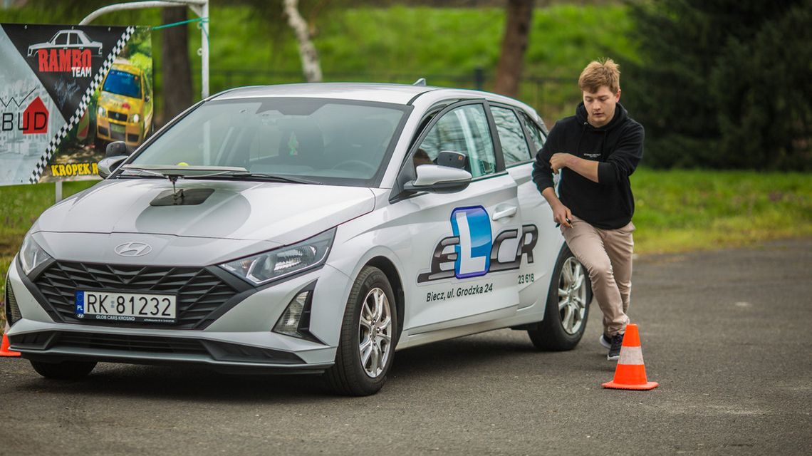 zdjęcie przedstawia chłopaka biegnącego obok samochodu