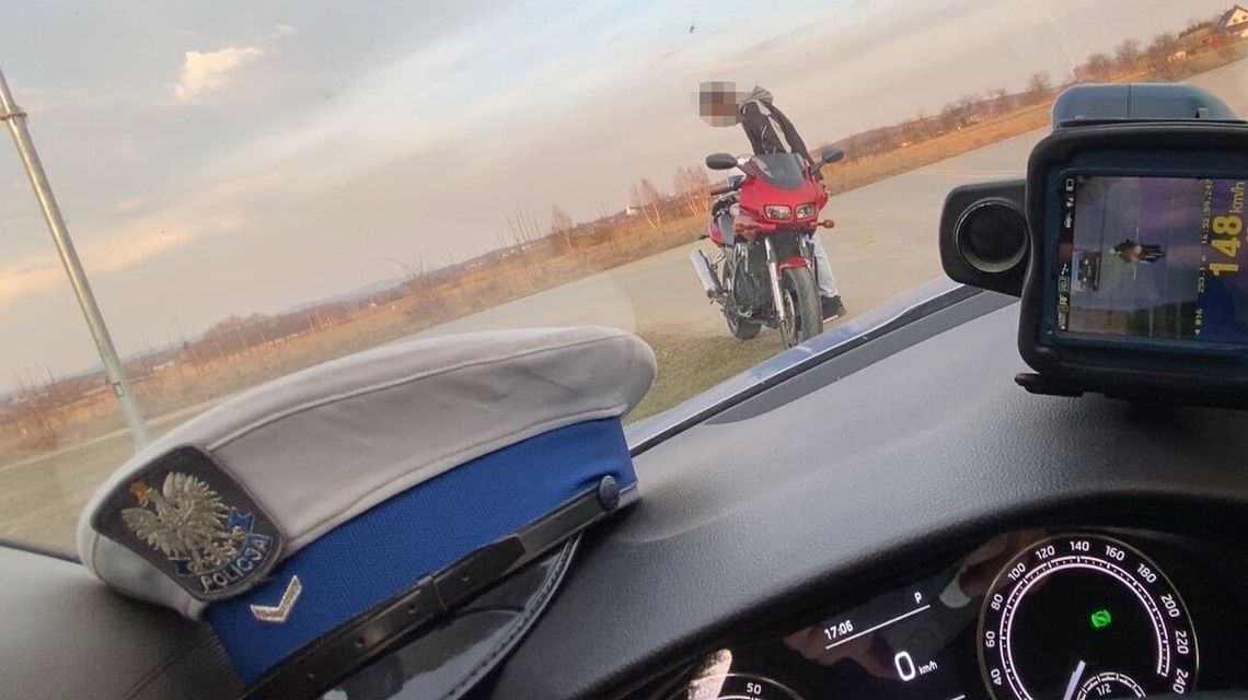 zdjęcie przedstawia mężczyznę stojącego przy motocyklu