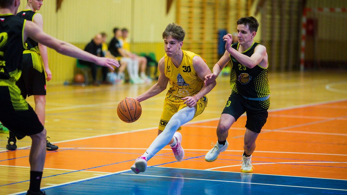 zdjęcie przedstawia dwóch koszykarzy walczących o piłkę