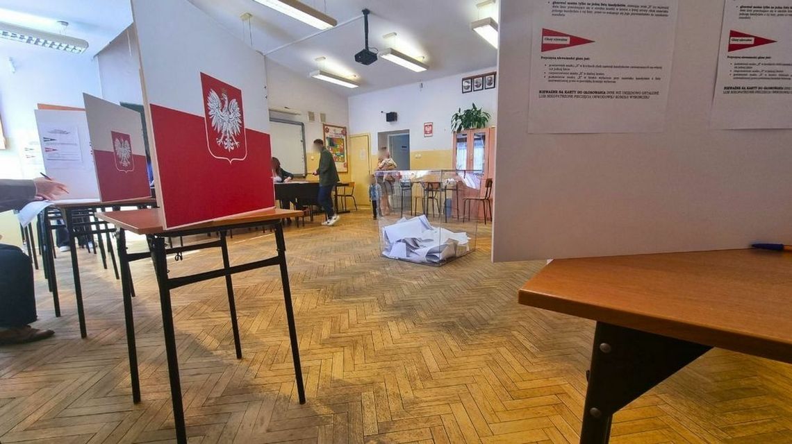 zdjęcie przedstawia lokal wyborczy, na środku urna