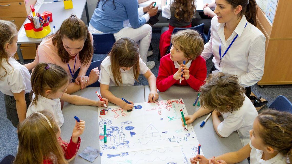 zdjęcie przedstawia dzieci przy ławce w szkole