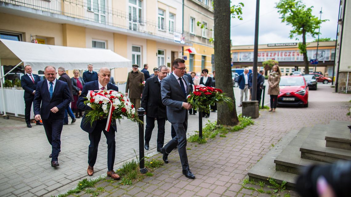 zdjęcie przedstawia mężczyzn w garniturach składających kwiaty przed tablicą upamiętniającą ks. Swieykowskiego