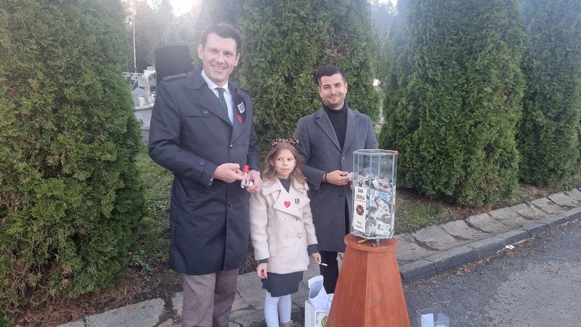 zdjęcie przedstawia dwóch mężczyzn i dziewczynkę przed puszką