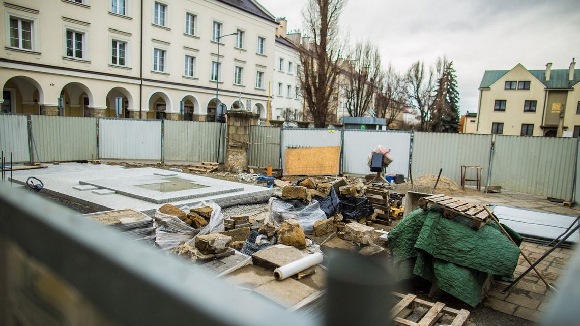 widok na plac budowy, taczki, gruz, ułożona posadzka w otoczeniu blaszanych barier