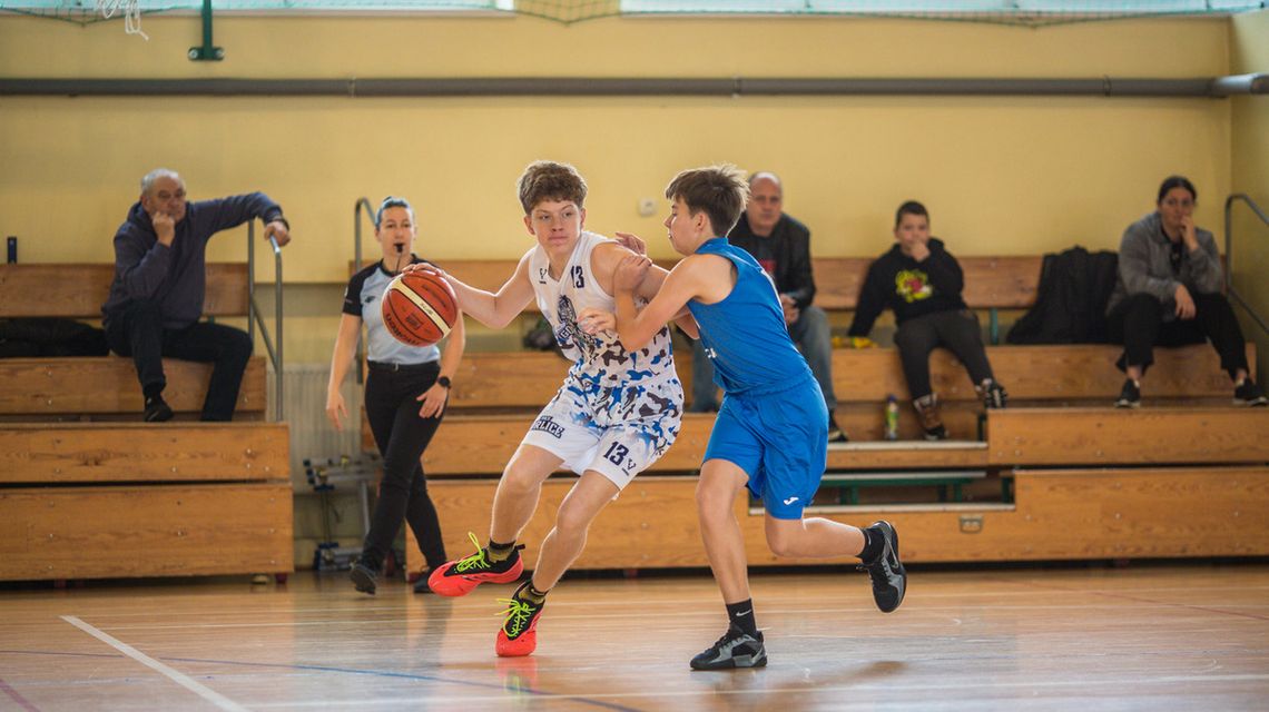 zdjęcie przedstawia koszykarzy walczących o piłkę